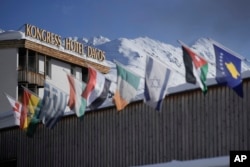 International flags wave on top of the Davos Congress Center where the World Economic Forum takes place in Davos, Switzerland, Monday, Jan. 15, 2024.(AP Photo/Markus Schreiber)