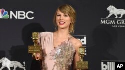 FILE - Taylor Swift poses in the press room with the award for top female artist and the award for top selling album for "reputation" at the Billboard Music Awards at the MGM Grand Garden Arena on Sunday, May 20, 2018, in Las Vegas. (Photo by Jordan Strauss/Invision/AP)