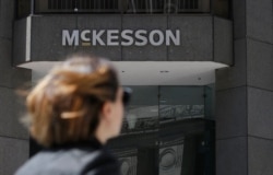 FILE - A pedestrian passes a McKesson sign on an office building in San Francisco, July 17, 2019.