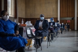 FILE- Health care workers await doses to start vaccinating people with Pfizer vaccines at the Bertha Gxowa Hospital in Germiston, South Africa, May 17, 2021.