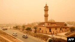 FILE—Motorists drive their vehicles through a sandstorm in Libya's eastern city of Benghazi on April 22, 2024.