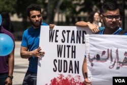 Protesters hold signs at a rally in support of the Sudan's revolution, in Chicago, Illinois, June 29, 2019. (J. Patinkin/VOA)