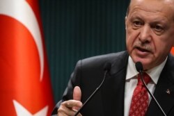 FILE - Turkish President Recep Tayyip Erdogan gestures as he delivers a speech following a cabinet meeting, in Ankara, on June 9, 2020.