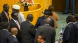 South Sudan's rebel leader Riek Machar, center-left with back to camera, shakes hands with South Sudan's President Salva Kiir, center-right wearing a black hat, after lengthy peace negotiations in Addis Ababa, Ethiopia, Aug. 17, 2015.