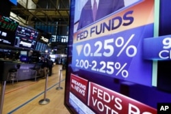 FILE - A television monitor on the floor of the New York Stock Exchange headlines a rate decision of the Federal Reserve, in New York, July 31, 2019.