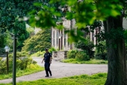 A policeman patrols past the home of Bill Cosby in Elkins Park, Pa., Wednesday, June 30, 2021. Pennsylvania's highest court has overturned comedian Cosby's sex assault conviction.