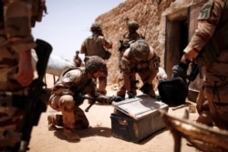 FILE - French soldiers of the 2nd Foreign Engineer Regiment search a metal case during an area control operation in the Gourma region during Operation Barkhane in Ndaki, Mali, July 27, 2019.