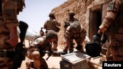 Des soldats français du 2e Régiment étranger du génie fouillent une caisse métallique lors d'une opération de contrôle de zone dans la région du Gourma lors de l'opération Barkhane à Ndaki, au Mali, le 27 juillet 2019.