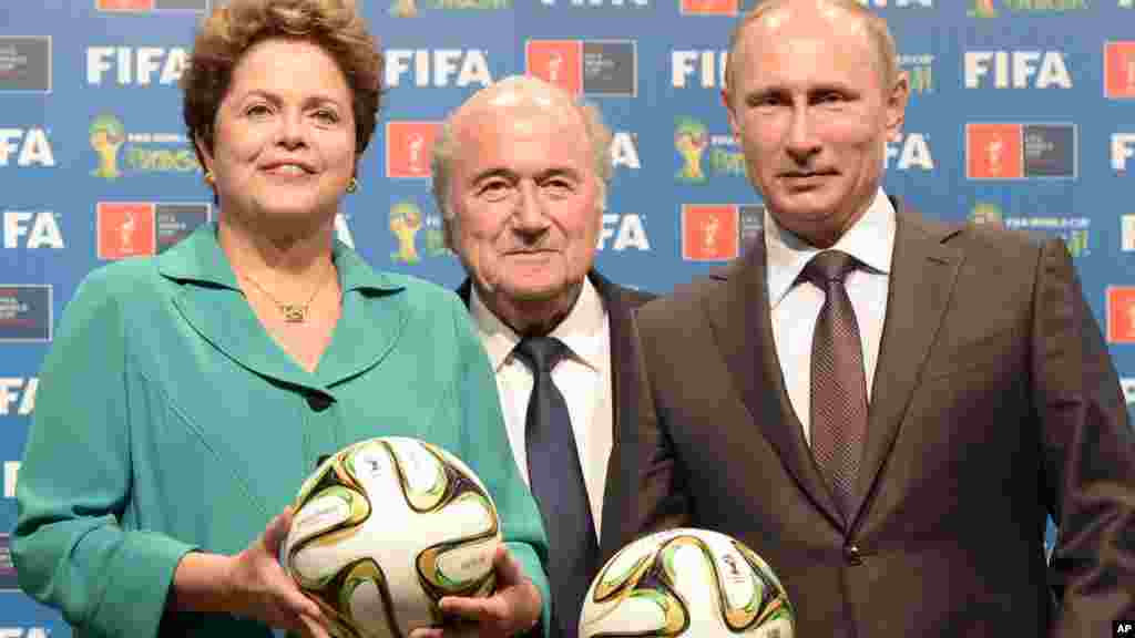 A wannan hoto da aka dauka ran 13 ga watan Yuli 2014, Shugabar Brazil Dilma Rouseff ce tare da Shugaban Fifa Sepp Blatter daga hagu, shi yana tsakiya, sannan Shugaban Rasha Vladimir Pitin sun shirya wa hasken hoto a lokacin taron mikawa Rasha a hukumance takardar amincewa da ita a matsayin mai masaukin karbar bakin Gasar Cin Kwallon Kafa na Duniya a Shekara ta 2018. AP