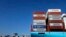FILE - Containers are stacked on a ship in the port of Lazaro Cardenas, Mexico, Nov. 21, 2013. 