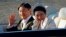 Kaisar Jepang Naruhito, kiri, dan Permaisuri Masako, kanan, melambaikan tangan selama iring-iringan kerajaan di Tokyo, Minggu, 10 November 2019. (AP Photo/Eugene Hoshik)