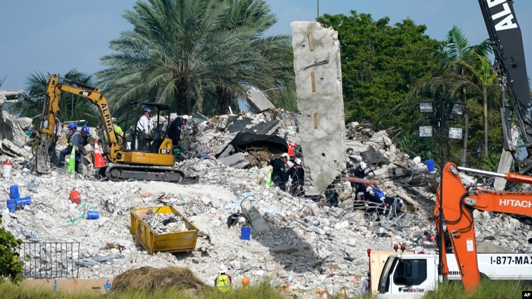 Para petugas penyelamat melanjutkan pencarian korban di antara reruntuhan bangunan kondominium "Champlain Towers South" di Surfside, Florida, Senin 5 Juli 2021. 