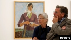 Visitors stand in front of the painting "The Brigadier" by Albanian artist Spiro Kristo during the documenta 14 art exhibition in the National Museum of Contemporary Art in Athens, Greece, May 9, 2017.