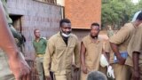 Makomborero Haruzivishe (with a book in hand) talking to reporters as he leaves Harare Magistrates Court on April 6, 2021 for Chikurubi Maximum Prison after being sentenced to 14 months in jail for inciting violence. (VOA/Columbus Mavhunga)