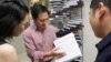 FILE - Scientist He Jiankui shows "The Human Genome", a book he edited, at his company Direct Genomics in Shenzhen, Guangdong province, China, Aug. 4, 2016. 