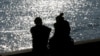 FILE - A couple is silhouetted at the harbor of Livorno, central Italy, Feb. 14, 2017.