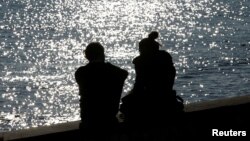 FILE - A couple is silhouetted at the harbor of Livorno, central Italy, Feb. 14, 2017.