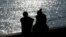 FILE - A couple is silhouetted at the harbor of Livorno, central Italy, Feb. 14, 2017.