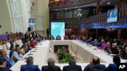 El presidente de la Asamblea Nacional, Jorge Rodríguez, arriba al centro, encabeza una reunión con organizaciones políticas para acordar una fecha para las elecciones generales de este año, en Caracas, Venezuela, el 14 de febrero de 2024. (Foto AP/Matías Delacroix)