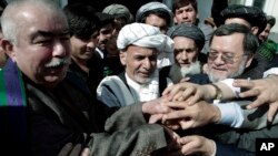 Ashraf Ghani, former Afghan finance minister, center, joins hands with his supporters after registering his candidacy in next year's presidential election, in Kabul, Afghanistan, Sunday, Oct. 6, 2013. 