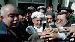 Ashraf Ghani, mantan menteri keuangan Afghanistan (tengah), berjabatan tangan dengan para pendukungnya. setelah mendaftarkan kepesertaannya dalam pemilihan presiden 2014 di Kabul (6/10). 