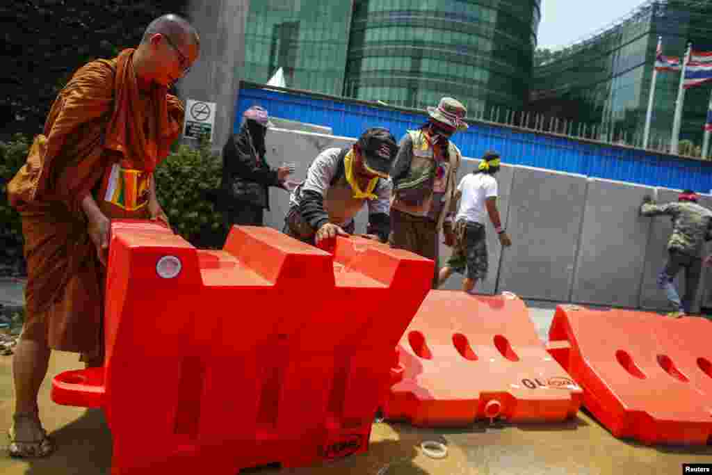 Anti-government protesters remove barricades during a rally outside the Ministry of Energy in Bangkok, March 6, 2014. 