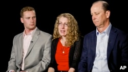 FILE - Evelyn Piazza, center, seated with her husband Jim, right, and son Michael, speaks during an interview May 15, 2017, in New York. The Piazzas talked about Tim Piazza, 19, a brother, son and Penn State sophomore who died in February after he was put through a hazing ritual at his fraternity house and forced to drink dangerous amounts of alcohol in a short amount of time.