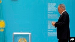 FILE - Nursultan Nazarbayev, Kazakhstan's president, walks to casts his ballot at a polling station in Astana in the country's last presidential election, April 26, 2015.