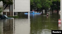 Texas City fire fighter/paramedic Allen Jacobs shouts for people wanting to be evacuated from the Hurricane Harvey floodwaters in Dickinson, Texas Aug. 28, 2017.