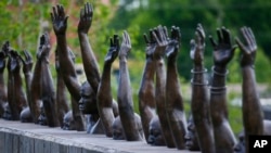 Patung tembaga yang diberi judul "Raise Up," salah satu karya yang dipamerkan di Memorial Nasional untuk Perdamaian dan Keadilan, museum baru untuk menghormati para korban "lynching," Senin, 23 April 2018, di Montgomery, Alabama.