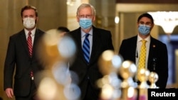 Senate Majority Leader Mitch McConnell of Kentucky, center, walks to the Senate Chamber before a cloture vote on overriding the veto of the National Defense Authorization Act on Capitol Hill in Washington, Jan. 1, 2021.