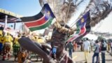 FILE - A South Sudanese man wears a headdress of feathers and the national flag, as he attends an independence day ceremony in the capital Juba, South Sudan, Thursday, July 9, 2015.