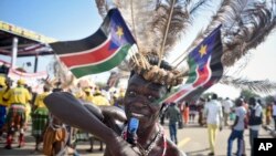 FILE - A South Sudanese man wears a headdress of feathers and the national flag, as he attends an independence day ceremony in the capital Juba, South Sudan, Thursday, July 9, 2015.