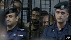 Guards surround the defendants' cage in state security court as judges sentenced 10 defendants to prison, with terms ranging from three years to life, for their role in an Islamic State attack on the Karak castle, a popular tourist site, Nov. 13, 2018, in