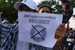 FILE - A protester against Myanmar's junta holds a placard criticizing the Association of Southeast Asian Nations (ASEAN), in Mandalay, Myanmar, June 5, 2021.