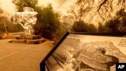 Pembungkus tahan api menutupi tanda selamat datang bersejarah saat Kompleks KNP di Taman Nasional Sequoia, California, terbakar, 15 September 2021. (AP Photo/Noah Berger)