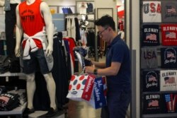 FILE - A man buys clothes at an American clothing store at a shopping mall in Beijing, China, July 15, 2019.