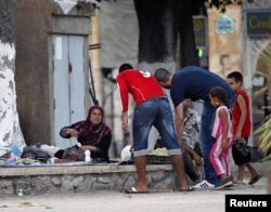Algerian volunteers distribute free food for iftar (breaking fast) to Syrian refugee families who fled the violence in Port Said Square in Algiers, July 30, 2012.