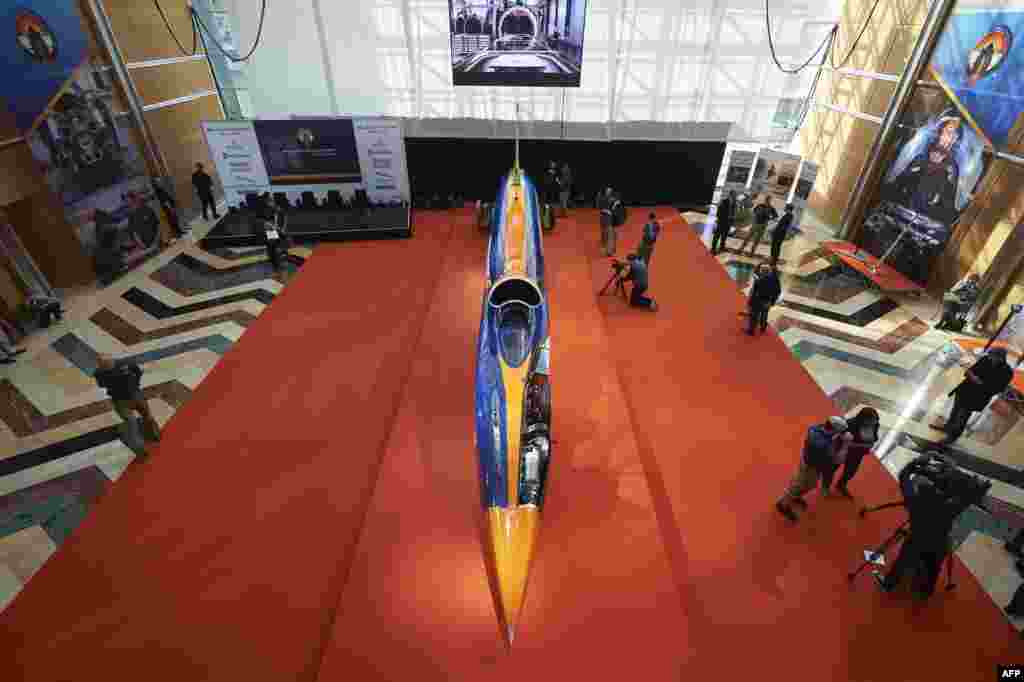 Visitors look at the Bloodhound Supersonic Car as it stands on display during a photocall to promote its World debut, at Canary Wharf in east London. The team behind the Bloodhound SCC is hoping to break the world land speed record in South Africa in 2016. The supersonic car is a mix of car and aircraft technology, and is powered by a jet engine and a rocket together with a auxiliary gasoline engine.