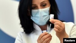 A health worker prepares to administer the AstraZeneca vaccine under the COVAX scheme against the coronavirus disease (COVID-19) in Pristina, Kosovo March 29, 2021. REUTERS/Laura Hasani