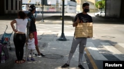 Una familia de inmigrantes venezolanos pide ayuda en la calle en Guayaquil, Ecuador, para retornar a su país el 20 de abril de 2020.