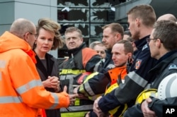Belgium's Queen Mathilde, second left, visits firefighters and first responders in front of the damaged Zaventem Airport terminal in Brussels on March 23, 2016.