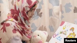 Pakistani schoolgirl Malala Yousufzai reads a card as she recuperates at the The Queen Elizabeth Hospital in Birmingham in this undated handout given to Reuters on November 8, 2012. 