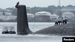 Para anggota kru bekerja di kapal selam bertenaga nuklir Rusia "Kazan" yang berlabuh di Teluk Havana, Kuba, 12 Juni 2024.