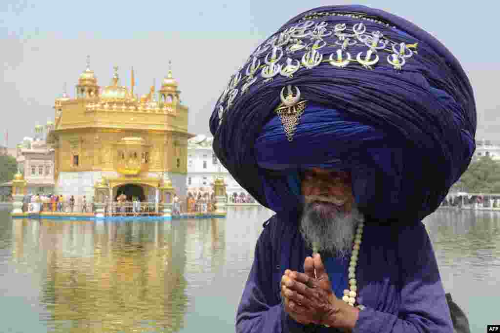 Indian Sikh Nihang (a traditional Sikh religious warrior) Baba &#39;Jagir&#39; Singh wears a giant turban at the Golden Temple in Amritsar on the eve of the 397th birth anniversary of the ninth Sikh Guru Teg Bahadur.