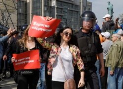 FILE - Police officers detain opposition supporters during a protest in Moscow, May 5, 2018. The posters read "I am against corruption."