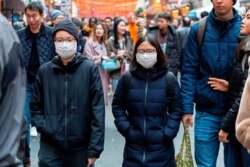 Pedestrians are seen wearing surgical masks in London's China Town, Jan. 25, 2020. European airports from London to Moscow have stepped up checks on flights from the Chinese city at the heart of a new coronavirus outbreak.