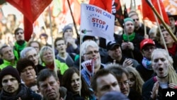 A man blows a whistle during a massive demonstration against the free trade agreements TTIP (Transatlantic Trade and Investment Partnership) and CETA (Comprehensive Economic and Trade Agreement) in Berlin, Oct. 10, 2015.