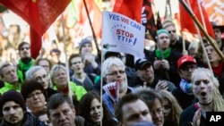 Tư liệu- Một người đàn ông thổi còi trong khi hàng chục ngàn người biểu tình tham dự một cuộc tuần hành chống các hiệp định thương mại tự do TTIP và CETA (Hiệp định kinh tế và thương mại toàn diện) ở Berlin, ngày 10 tháng 10 năm 2015.