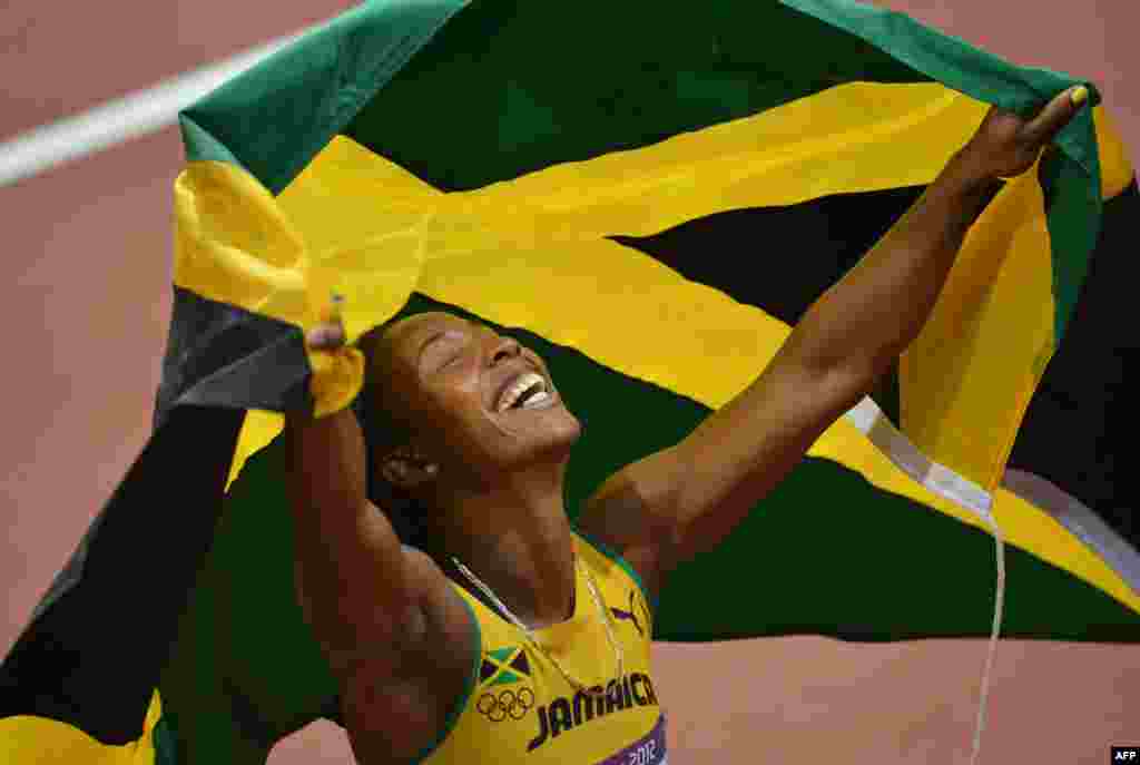 Jamaica's Shelly-Ann Fraser-Pryce celebrates after winning the women's 100m final at the athletics event of the London 2012 Olympic Games on August 4, 2012 in London. 